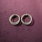 Flat lay image of Twisted Double-Rope Oxidized Toe Rings on maroon background