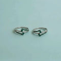 Dual Arch Emerald Toe Rings on solid background