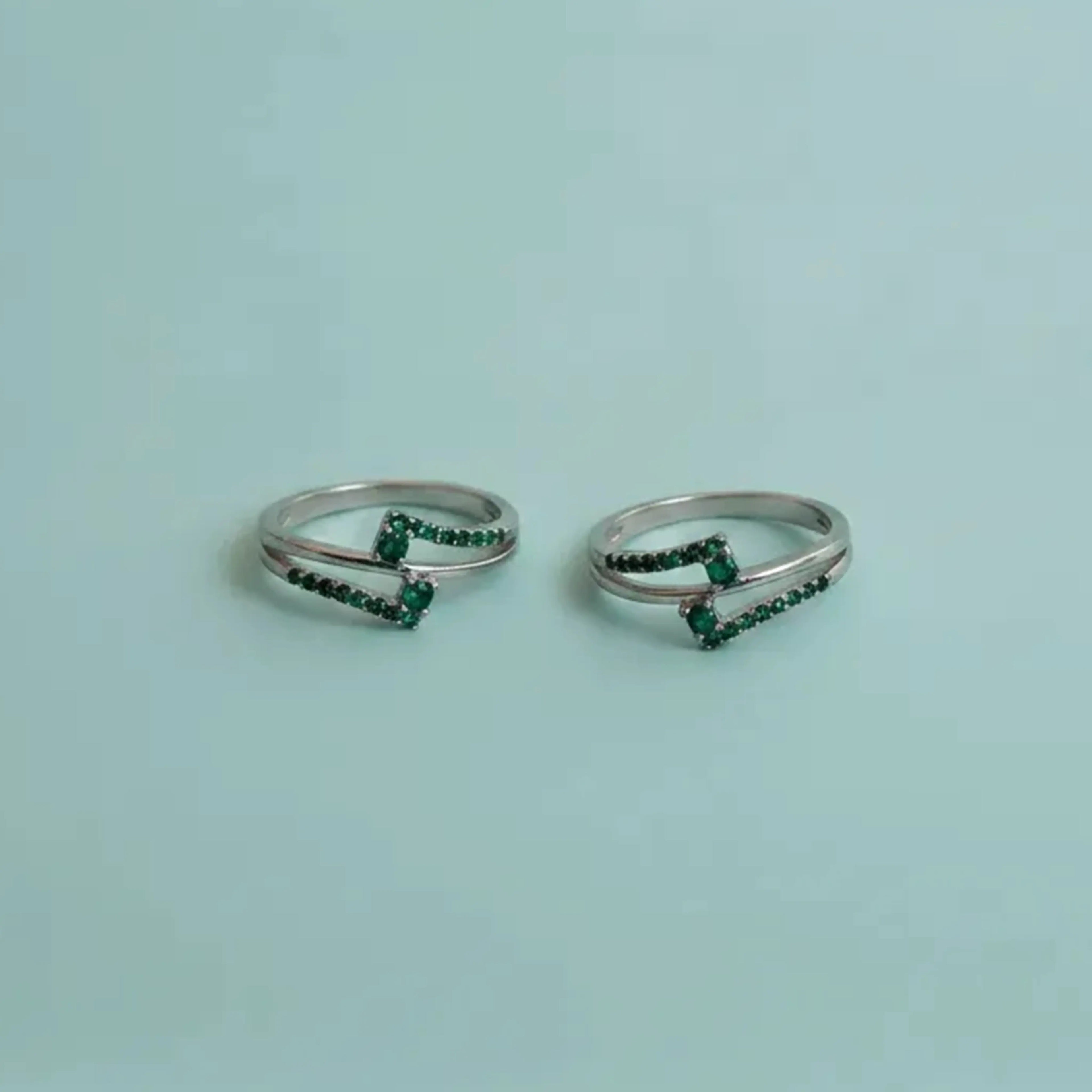Dual Arch Emerald Toe Rings on solid background