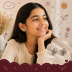 A smiling young girl with long dark hair rests her chin on her hand, wearing a small silver cactus stud earring. An inset cloud graphic on the bottom right shows a pair of silver cactus-shaped stud earrings.