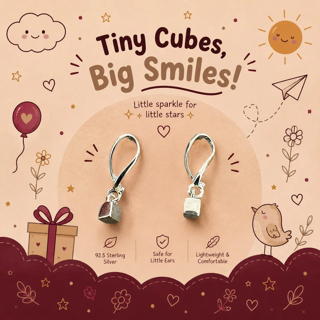 A pair of tiny sterling silver cube-shaped dangle earrings displayed on a decorative beige and burgundy card. The card features cute cartoon illustrations of a sun, cloud, bird, gift box, and stars, along with text that reads 'Tiny Cubes, Big Smiles!' and '92.