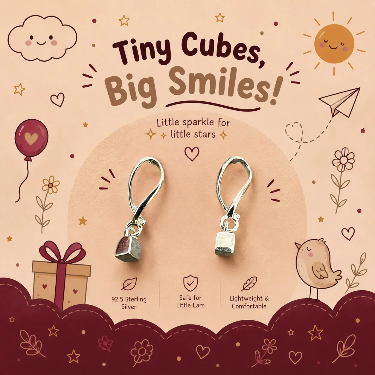 A pair of tiny sterling silver cube-shaped dangle earrings displayed on a decorative beige and burgundy card. The card features cute cartoon illustrations of a sun, cloud, bird, gift box, and stars, along with text that reads 'Tiny Cubes, Big Smiles!' and '92.