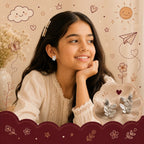 A young girl with long dark hair smiles while wearing a small silver earring, with a matching pair of silver leaf-shaped earrings displayed on a cloud-shaped tray in the foreground. The background is a warm beige with cute doodles of a sun, clouds, flowers, and stars.