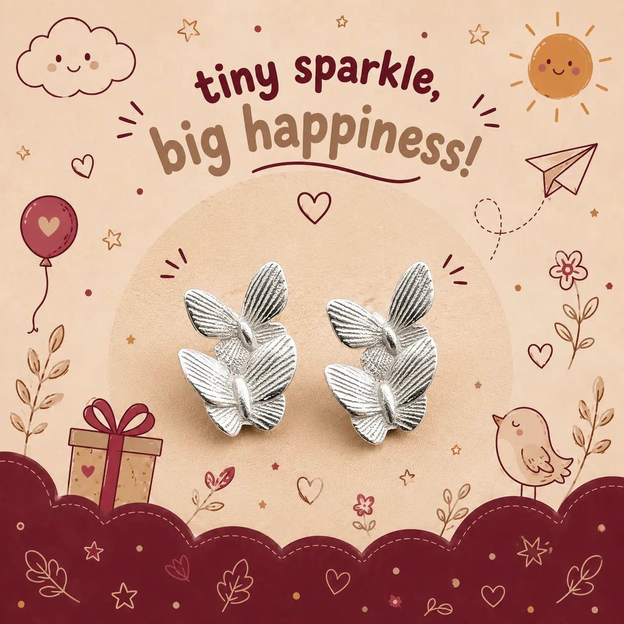 A pair of silver butterfly-shaped stud earrings displayed on a decorative illustrated backing card that reads 'tiny sparkle, big happiness!' with doodles of a sun, cloud, balloon, gift, bird, and stars.