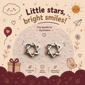 A pair of silver intertwined Stars stud earrings displayed on a textured circular card with decorative children's-themed illustrations and text reading 'Little stars, bright smiles!' and 'Tiny sparkle for big dreams.'.