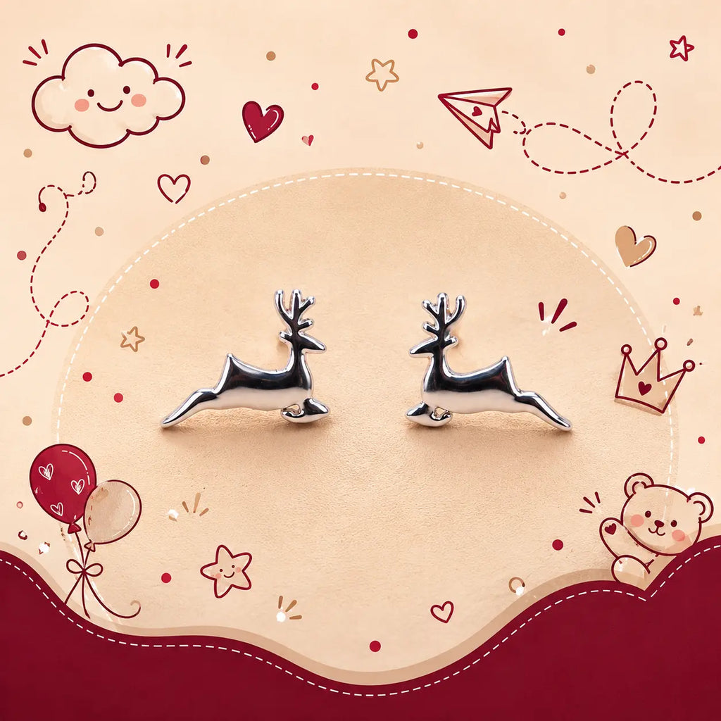 A pair of silver deer stud earrings displayed on a beige circular background with cute red and pink cartoon doodles including hearts, stars, balloons, a cloud, and a teddy bear.