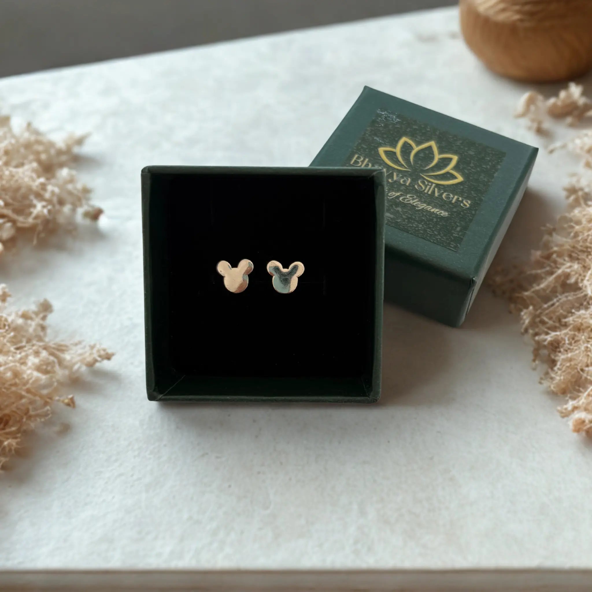 Pair of cartoon shaped stud earrings in green colored jewellery box 
